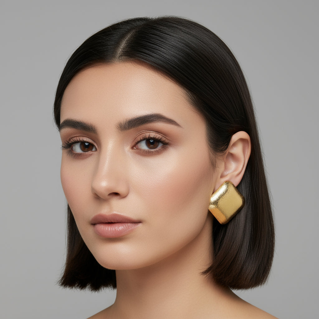 alt="Boucles d’oreilles Ophélia en acier inoxydable doré – design carré martelé effet miroir, bijou élégant et hypoallergénique"