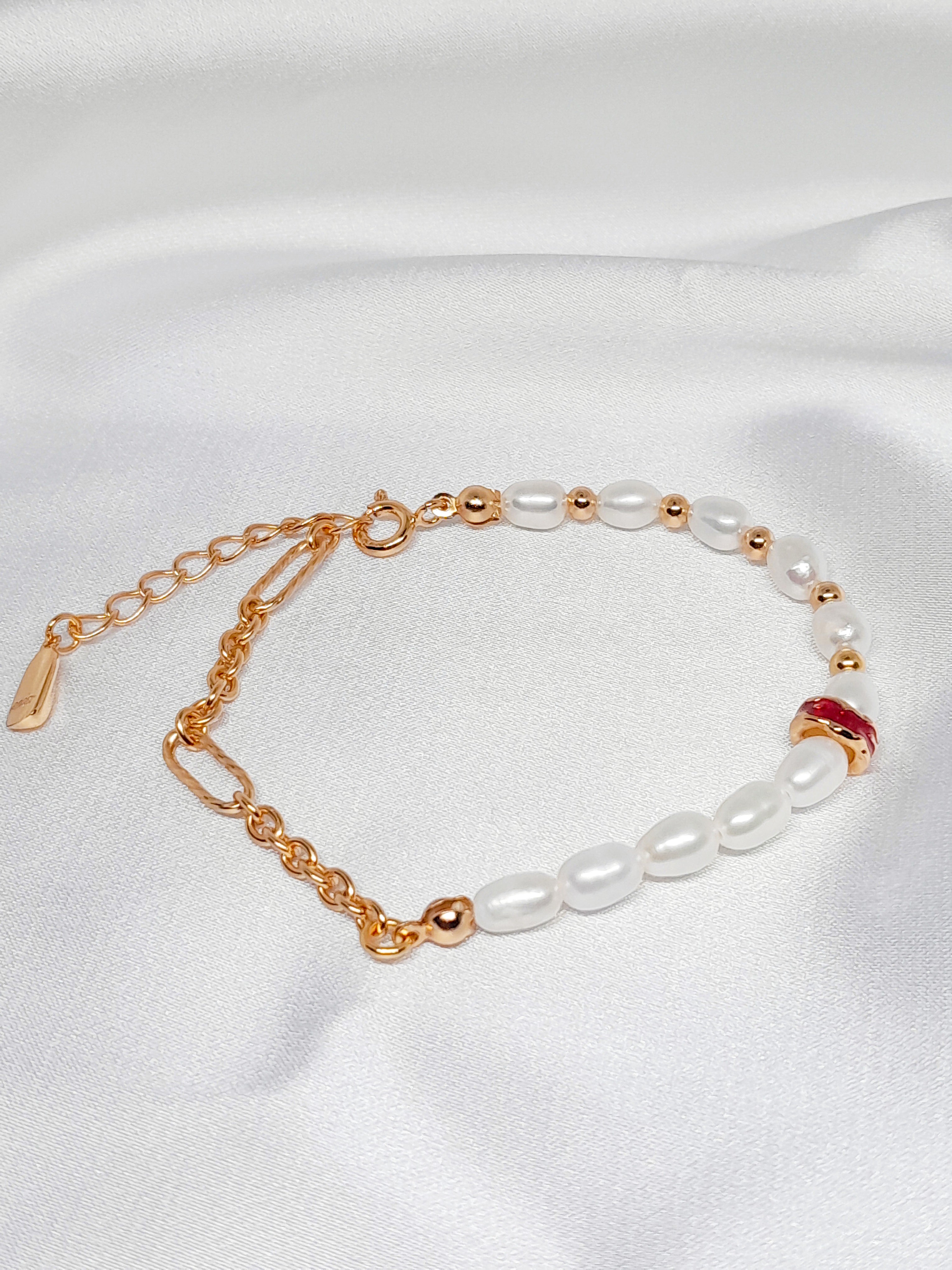 Bracelet Salva en argent sterling 925 plaqué or 18 carats, orné de perles de culture blanches et d’un détail rouge élégant, bijou raffiné Oréa Bijoux.