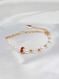 Bracelet Salva en argent sterling 925 plaqué or 18 carats, orné de perles de culture blanches et d’un détail rouge élégant, bijou raffiné Oréa Bijoux.