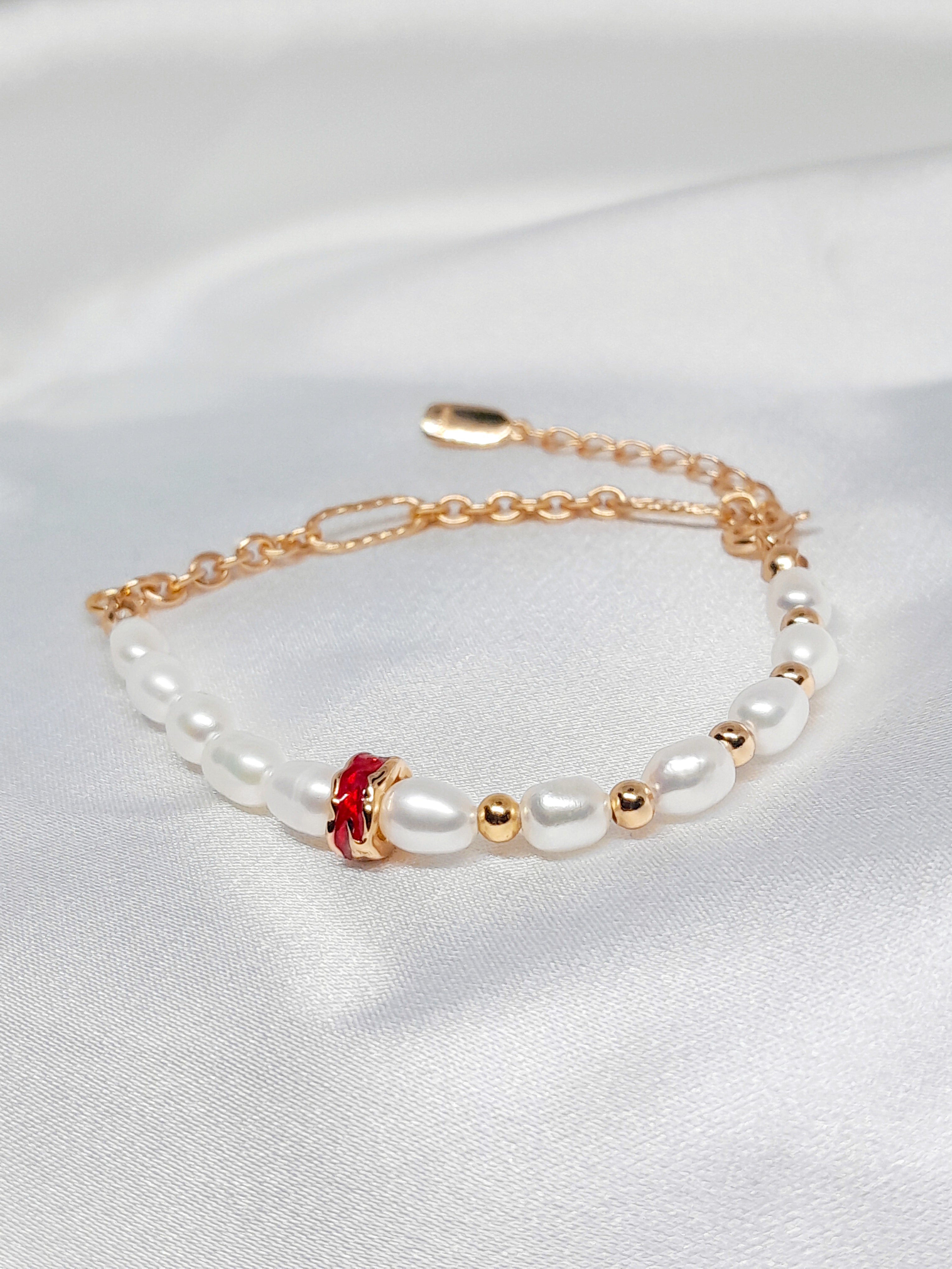 Bracelet Salva en argent sterling 925 plaqué or 18 carats, orné de perles de culture blanches et d’un détail rouge élégant, bijou raffiné Oréa Bijoux.