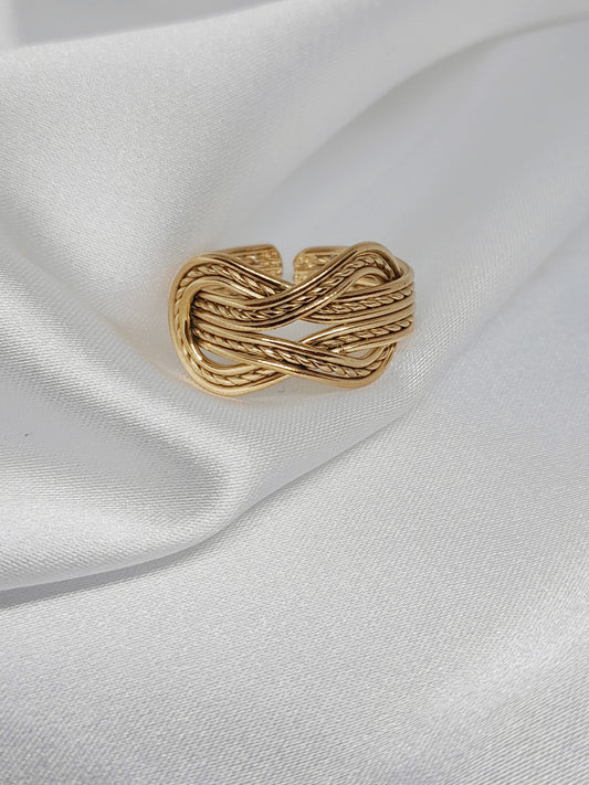 <img src="selva.jpg" alt="Bague Selva dorée en acier inoxydable avec design tressé et finition texturée">
