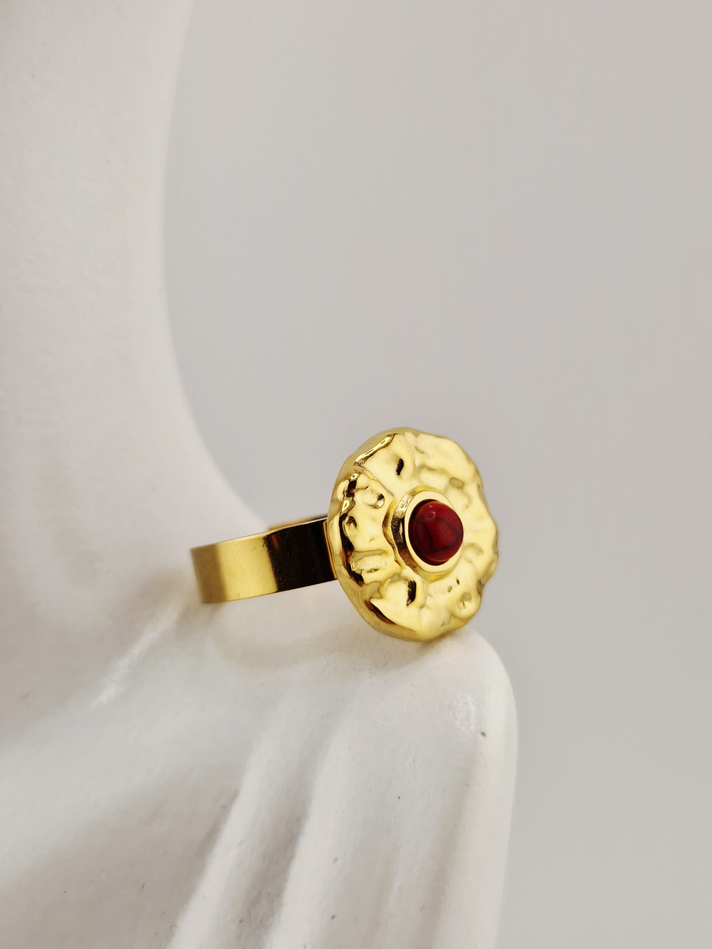 Bague Hélène dorée en acier inoxydable avec pierre rouge, effet martelé, résistante à l’eau et hypoallergénique.