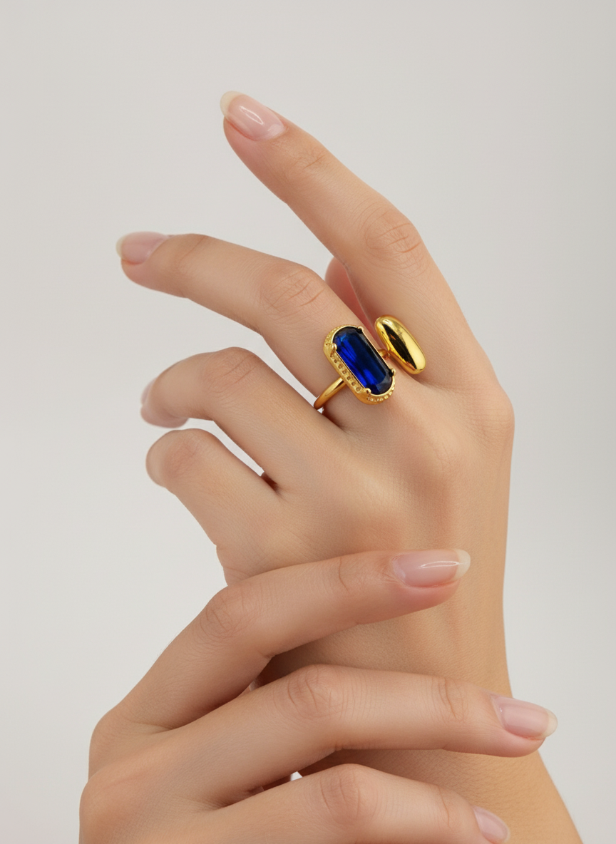 Bague dorée Gina en acier inoxydable avec pierre rectangulaire bleue sur fond neutre porté