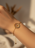 Bracelet en or sur tissu satin blanc, avec deux cercles concentriques dont l’un est serti de pierres brillantes porté