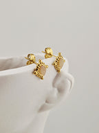 Boucles d’oreilles dorées Roxana en acier inoxydable avec pierre claire et détails perlés