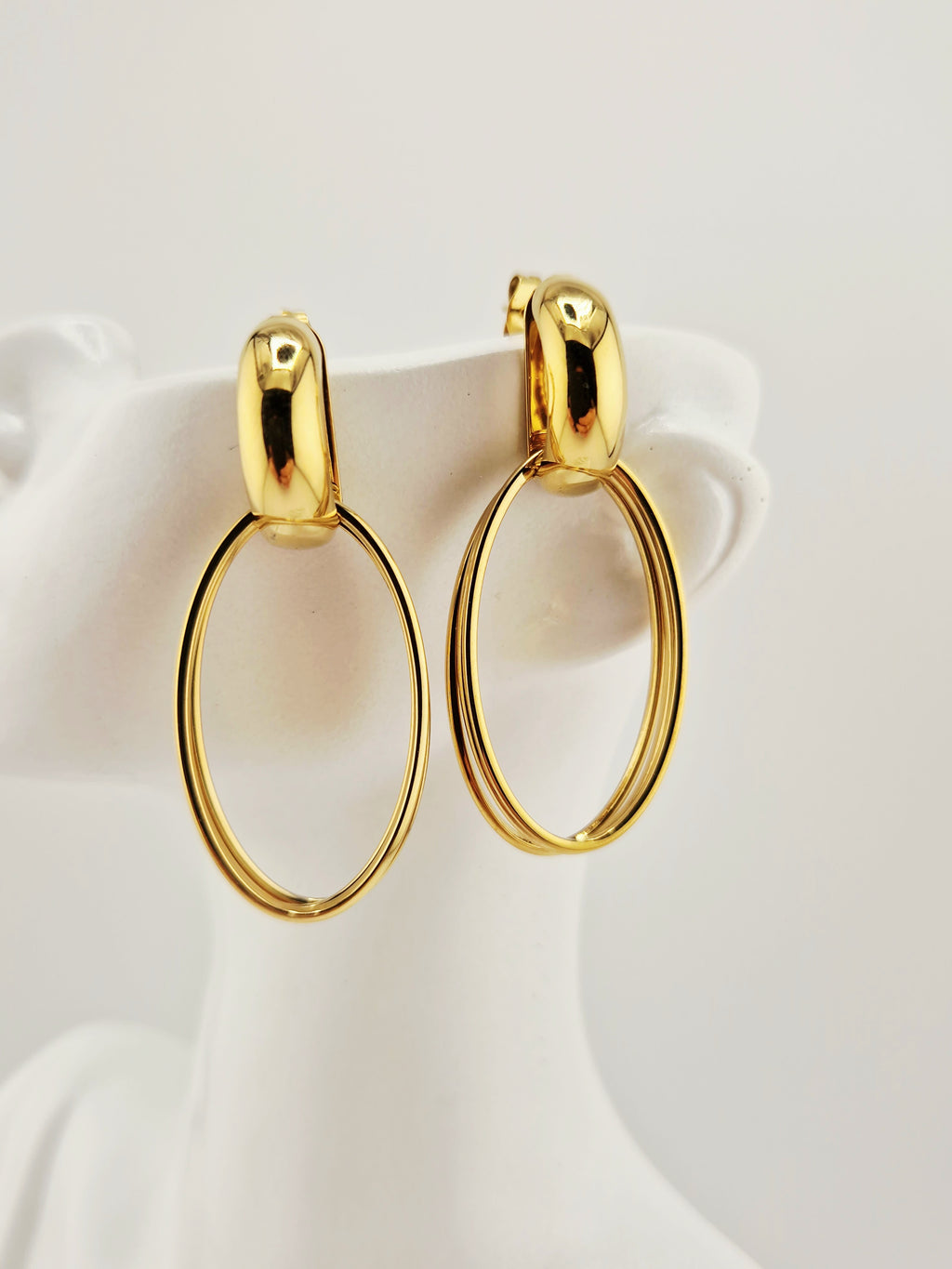 Boucles d’oreilles Héra dorées en acier inoxydable, design ovale chic sur buste blanc