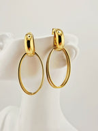 Boucles d’oreilles Héra dorées en acier inoxydable, design ovale chic sur buste blanc