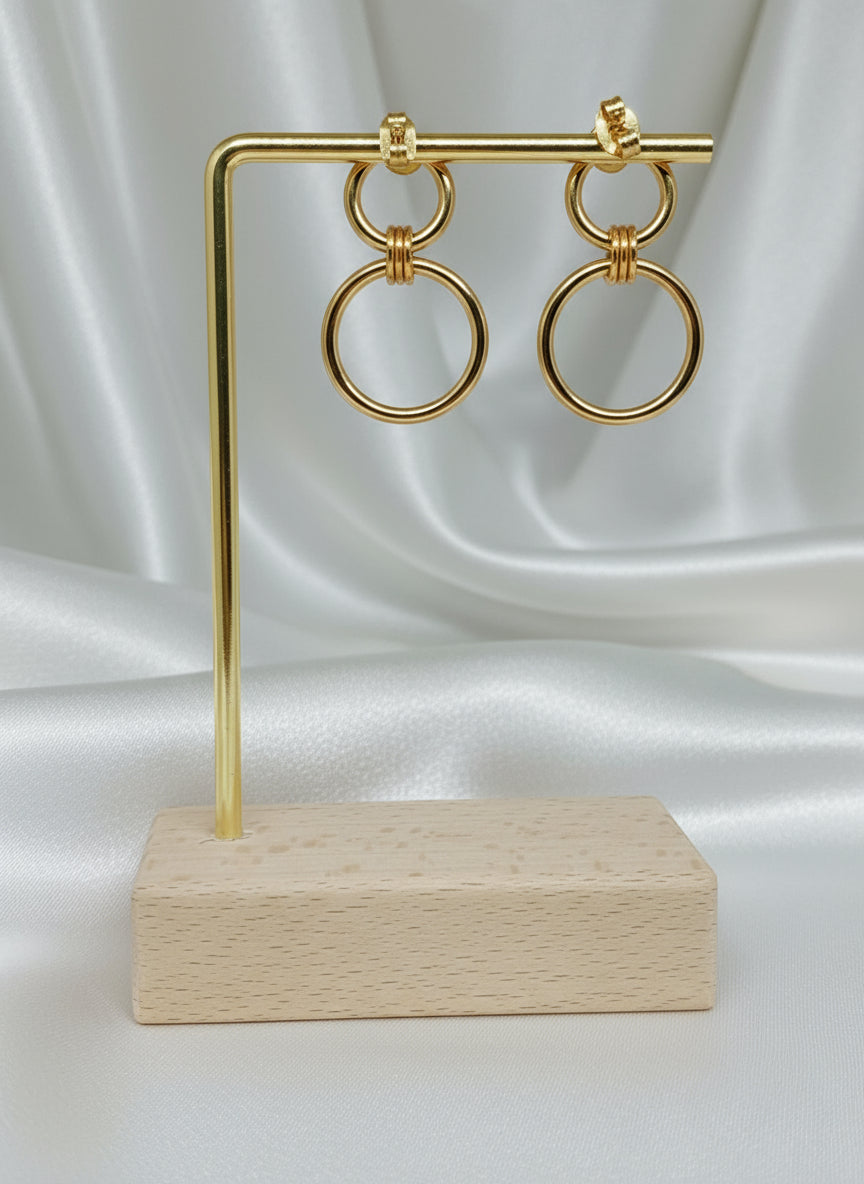 Boucles d’oreilles Énora dorées en acier inoxydable, design à deux anneaux entrelacés, longueur 3 cm, hypoallergéniques et résistantes à l’eau.