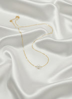 Collier Céline en acier inoxydable doré avec perle blanche nacrée, chaîne fine de 39 cm, bijou élégant et minimaliste.