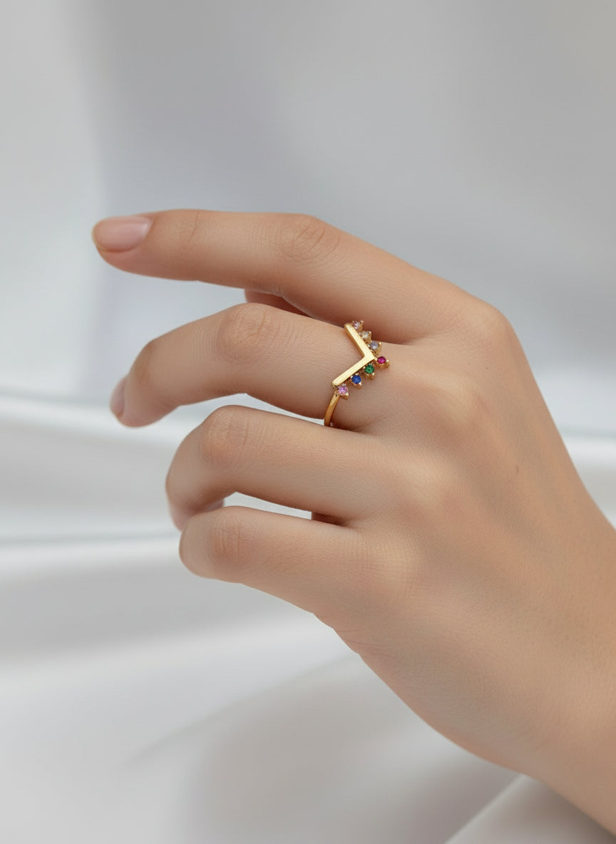 alt="Bague Melina dorée avec pierres colorées en dégradé sur fond blanc"