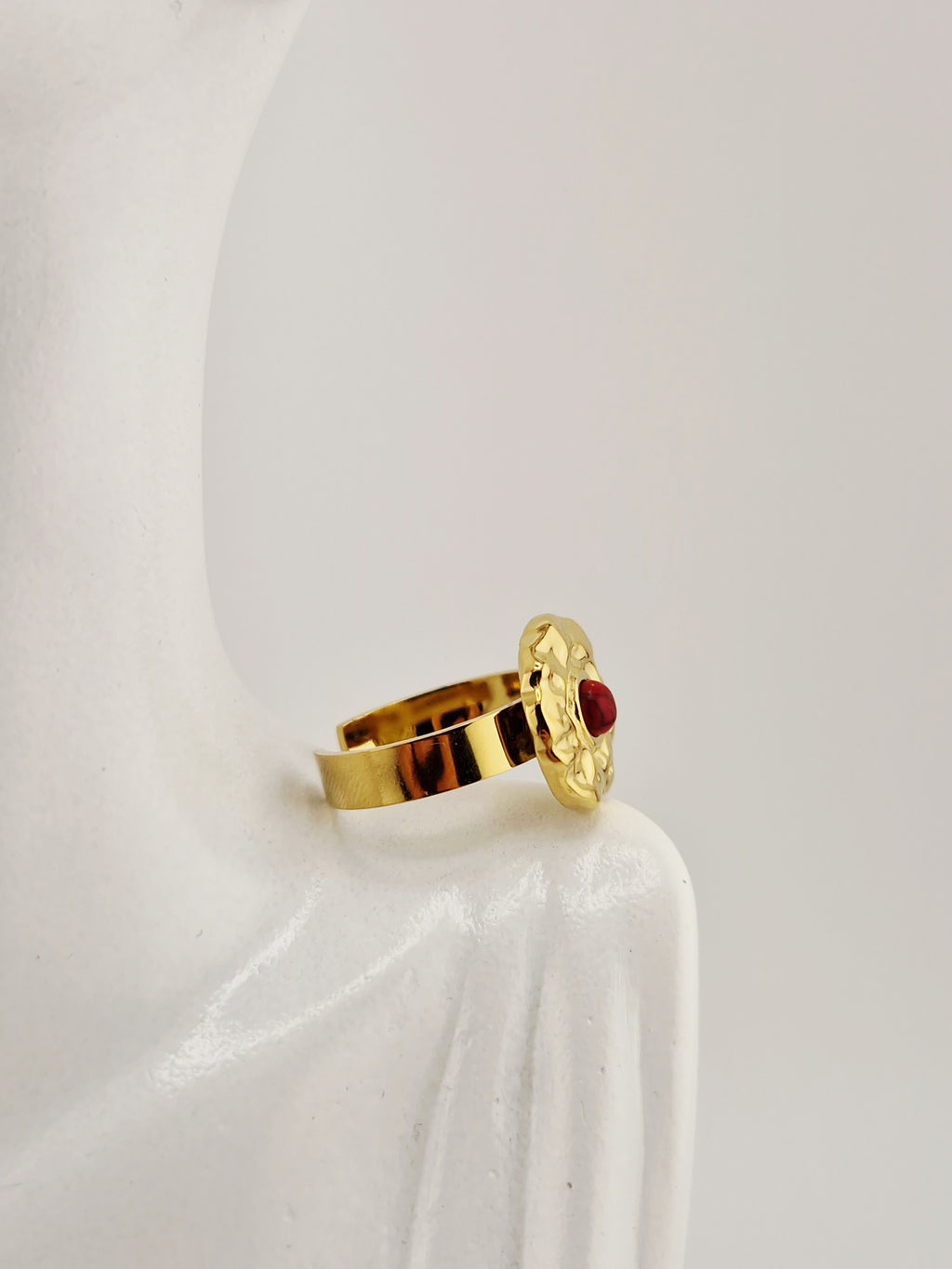 Bague Hélène dorée en acier inoxydable avec pierre rouge, effet martelé, résistante à l’eau et hypoallergénique.