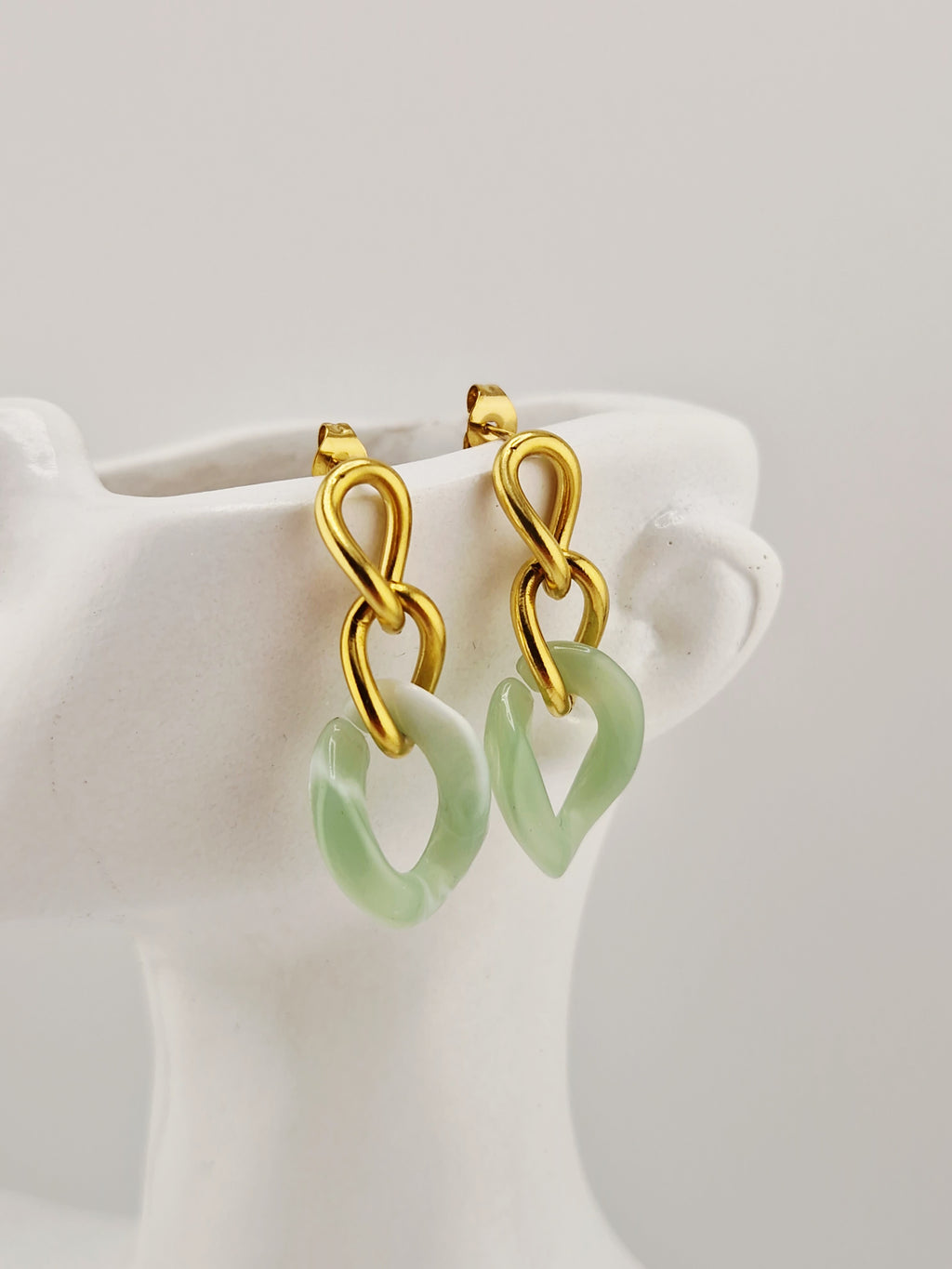 Boucles d’oreilles Yumi en acier inoxydable doré avec pendentifs  verts sur fond clair