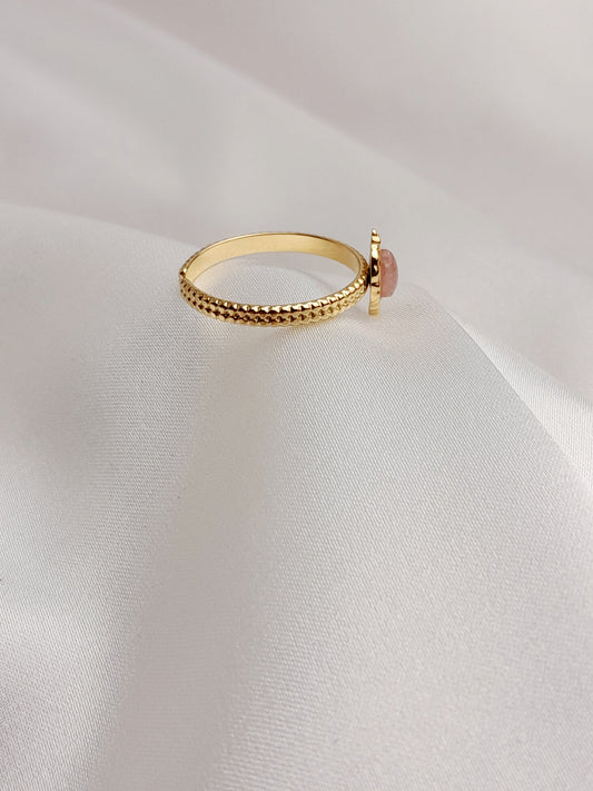 alt="Bague dorée ajustable avec pierre marquise rose sur fond blanc"
