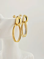 Boucles d’oreilles Héra dorées en acier inoxydable, design ovale chic sur buste blanc