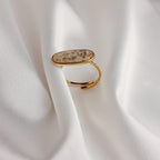 Bague Naya en acier inoxydable doré avec pierre naturelle ovale beige, bijou ajustable élégant et raffiné.