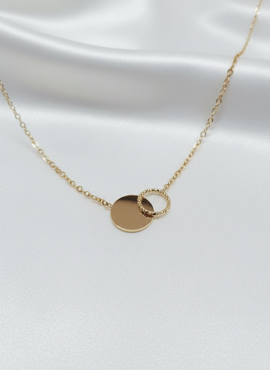 Collier Alicia doré en acier inoxydable avec deux cercles entrelacés sur fond satiné
