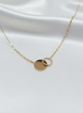 Collier Alicia doré en acier inoxydable avec deux cercles entrelacés sur fond satiné