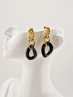 Boucles d’oreilles Yumi en acier inoxydable doré avec pendentifs verts sur fond clair