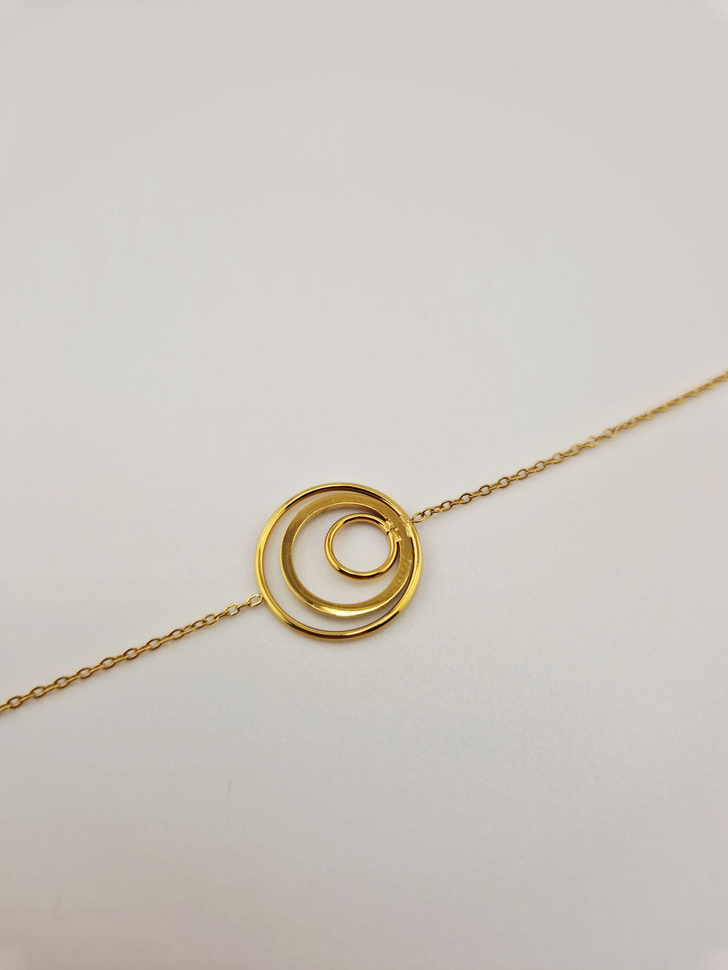 Bracelet en or sur tissu satin blanc, avec deux cercles concentriques dont l’un est serti de pierres brillantes