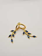 Boucles d’oreilles Éléa en acier inoxydable doré avec pendentif branche et pierres bleues.