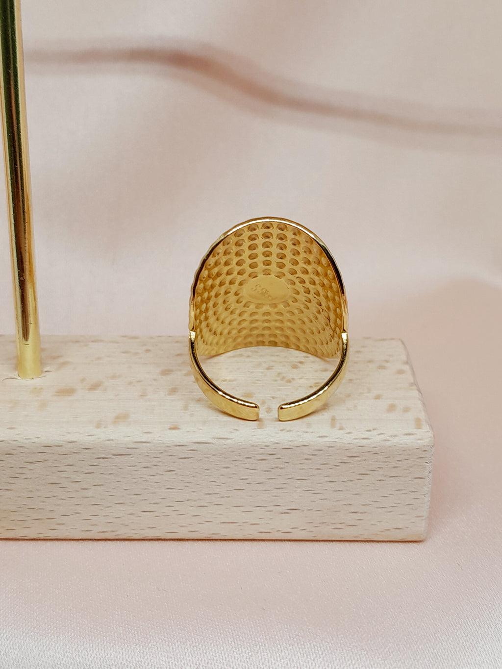 Bague Amal en acier inoxydable doré avec pierre verte sur fond satiné