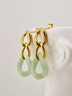 Boucles d’oreilles Yumi en acier inoxydable doré avec pendentifs  verts sur fond clair