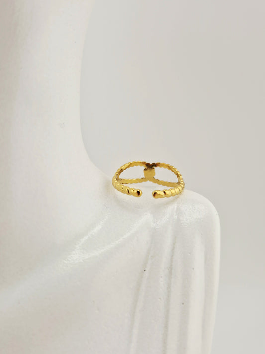 Bague christine dorée en acier inoxydable, design torsadé chic sur support blanc