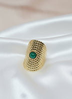 Bague Amal en acier inoxydable doré avec pierre verte sur fond satiné