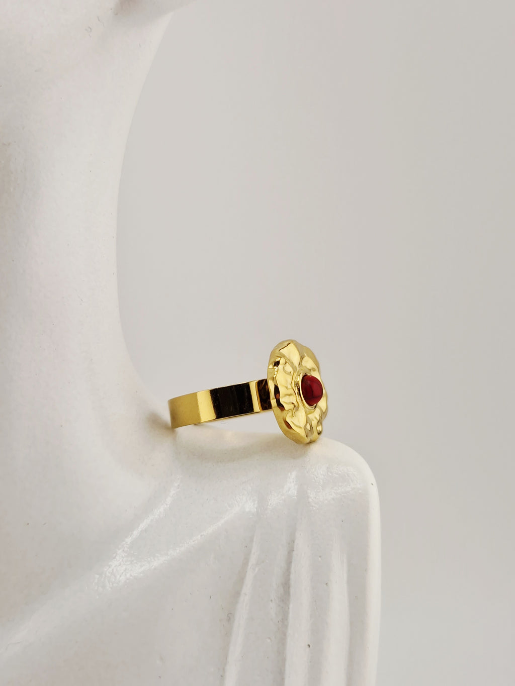 Bague Hélène dorée en acier inoxydable avec pierre rouge, effet martelé, résistante à l’eau et hypoallergénique.