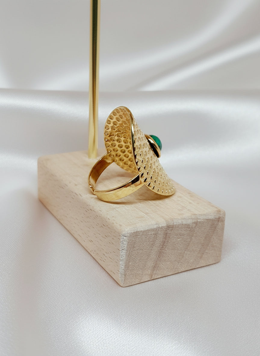 Bague Amal en acier inoxydable doré avec pierre verte sur fond satiné