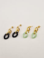 Boucles d’oreilles Yumi en acier inoxydable doré avec pendentifs noirs et verts sur fond clair