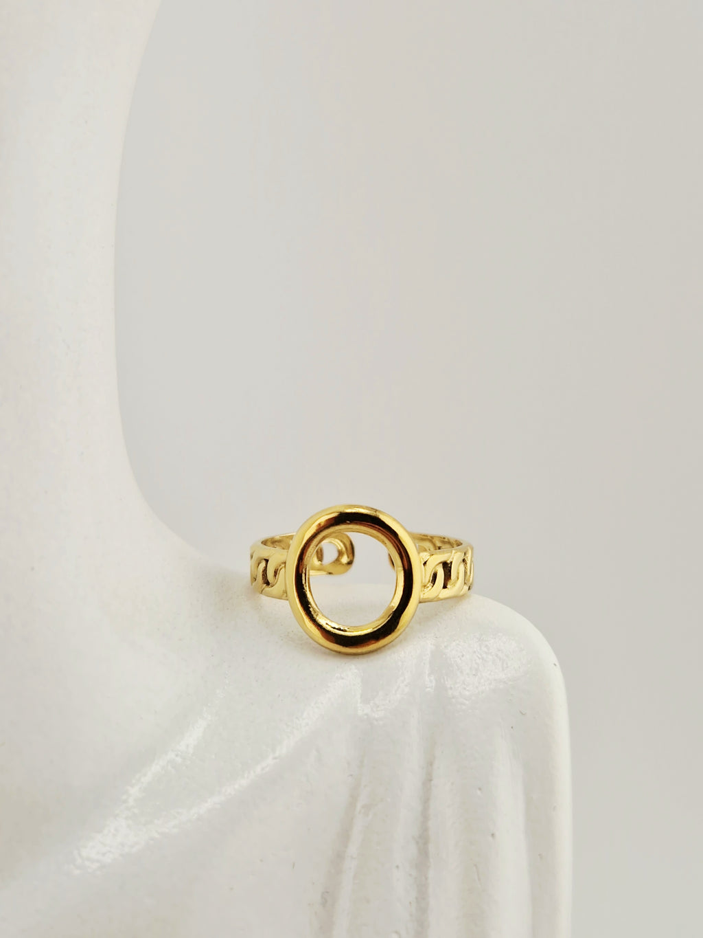 Bague dorée femme avec motif chaîne et cœur ajouré sur fond neutre