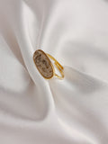 Bague Naya en acier inoxydable doré avec pierre naturelle ovale beige, bijou ajustable élégant et raffiné.