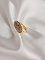 Bague Naya en acier inoxydable doré avec pierre naturelle ovale beige, bijou ajustable élégant et raffiné.