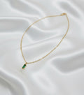 Collier Romy en acier inoxydable doré avec pendentif rectangulaire vert sur fond en satin
