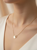 Collier Alicia doré en acier inoxydable avec deux cercles entrelacés sur fond satiné