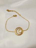 Bracelet en or sur tissu satin blanc, avec deux cercles concentriques dont l’un est serti de pierres brillantes