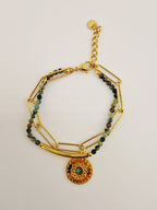 Bracelet Océane en acier inoxydable doré avec perles naturelles et médaillon décoratif.