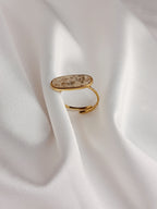 Bague Naya en acier inoxydable doré avec pierre naturelle ovale beige, bijou ajustable élégant et raffiné.
