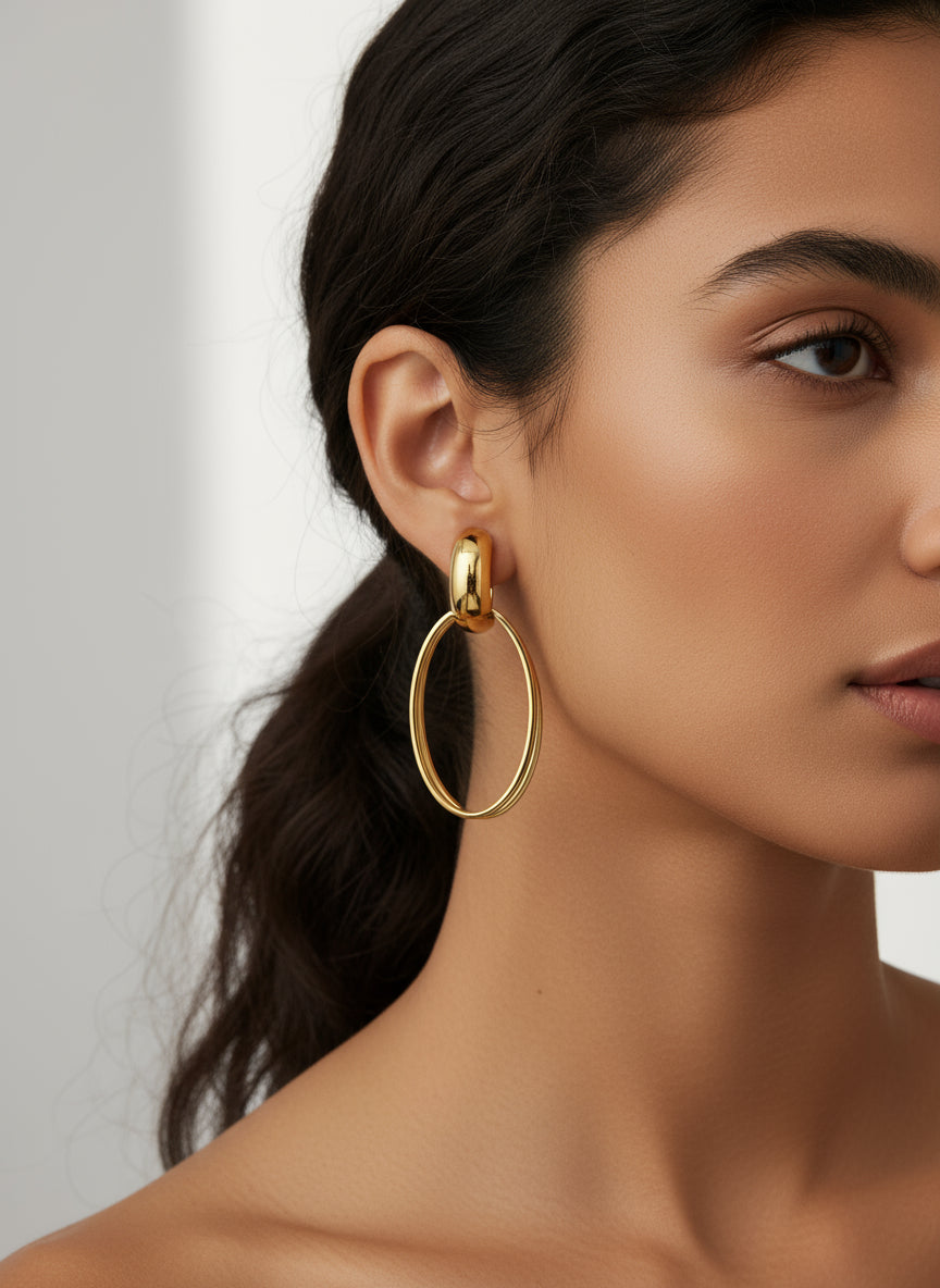 Boucles d’oreilles Héra dorées en acier inoxydable, design ovale chic sur buste blanc